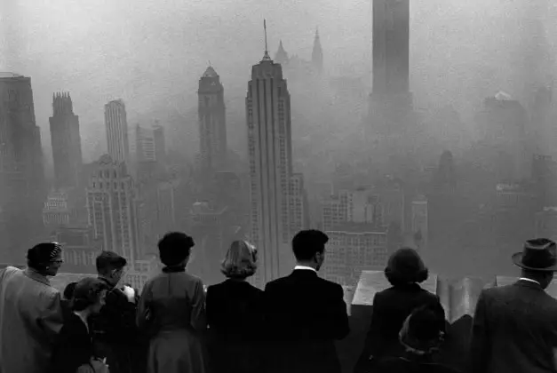 November 21st, 1953. "Several people standing on the top of a building looking down into the downtown misty smog that is covering the Empire State and surrounding buildings."